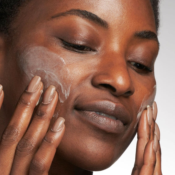 model applying cream to her face