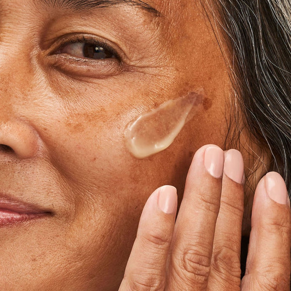 model applying the moisturiser to her face