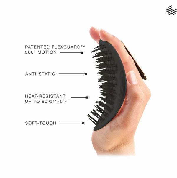 A hand holding a black flexible hairbrush against a white background, with text callouts reading 'PATENTED FLEXGUARD 360° MOTION', 'ANTI-STATIC', 'HEAT-RESISTANT UP TO 80°C/175°F', and 'SOFT-TOUCH'.