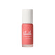 Lip balm with coral color and white cap on a light gray background