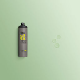 KMS Hair Play hair spray bottle on a green background