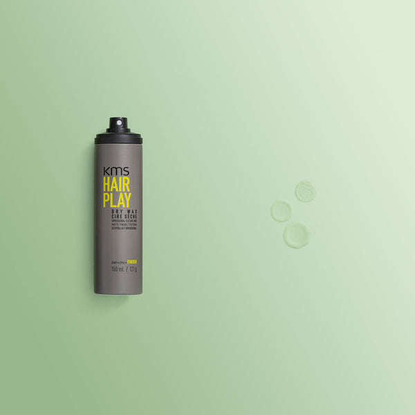 KMS Hair Play hair spray bottle on a green background