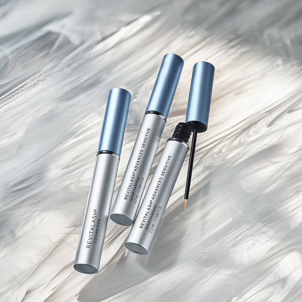 Three Revitalash Advanced Sensitive eye care products on a marble surface