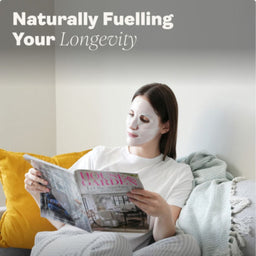 Woman reading a magazine with a face mask on, sitting on a couch.