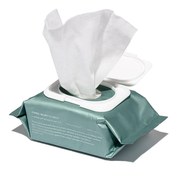 Green packet of facial wipes with a white tissue on a white background