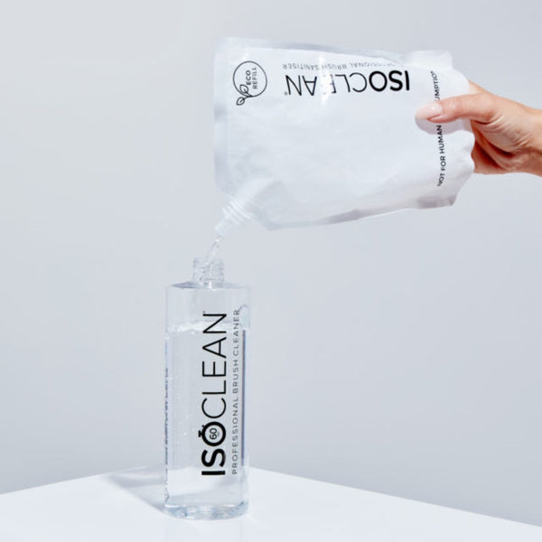 ISOCLEAN bottle and wipes on a white surface with a gray background