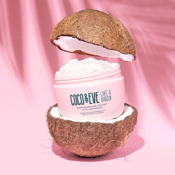 Coco & Eve Like A Virgin Super Nourishing Coconut & Fig Hair Masque between two coconut halfs