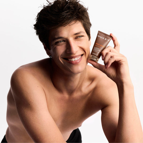Man holding a Nuxe product against a white background