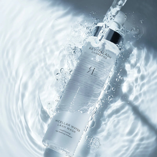 Revitalash Micellar Water Lash Wash bottle with water droplets and ripples in the background