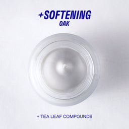 White cream jar with text '+ Softening Oak + Tea Leaf Compounds' on a light gray background