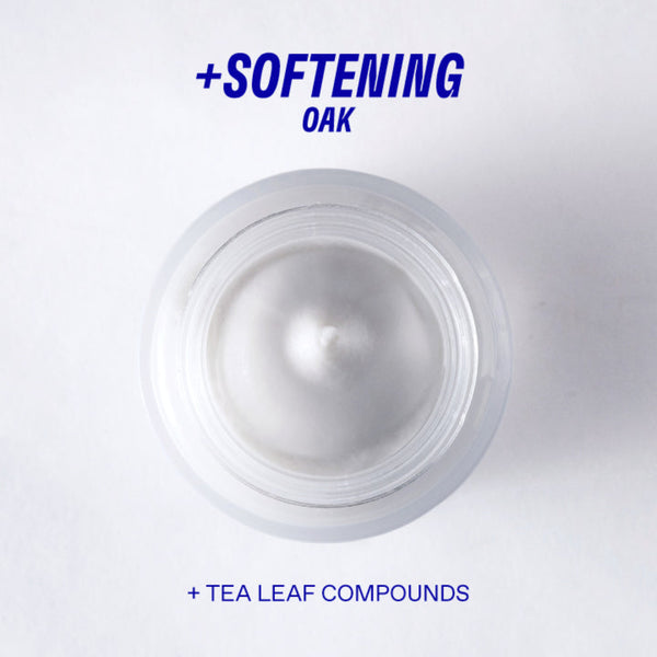 White cream jar with text '+ Softening Oak + Tea Leaf Compounds' on a light gray background