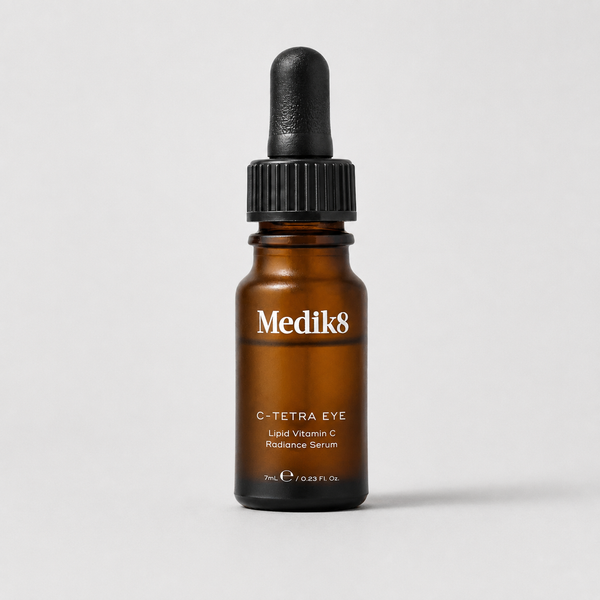 Medik8 C-Tetra Eye Liquid Vitamin C Radiance Serum in an amber glass dropper bottle with a black cap, centered on a light gray background.
