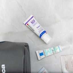 Cosmetic bag with skincare products on a light gray background