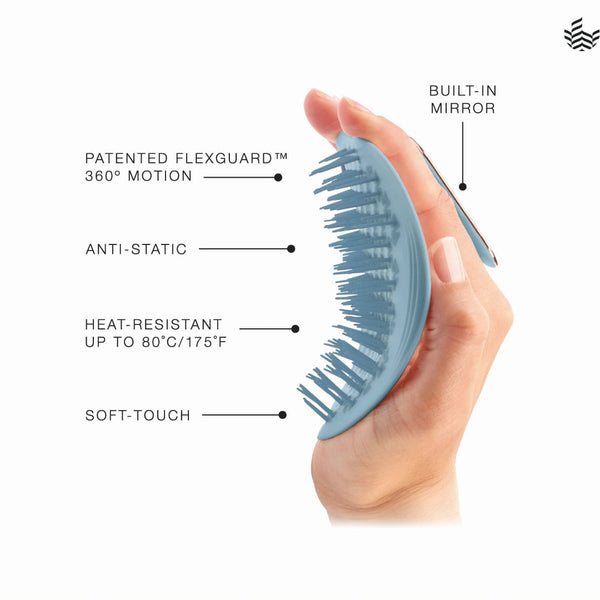 A hand holds a light blue detangling brush with a built-in mirror, shown on a white background with callout text describing features like patented flexguard 360° motion, anti-static protection, heat resistance up to 80°C/175°F, soft-touch texture, and a built-in mirror.
