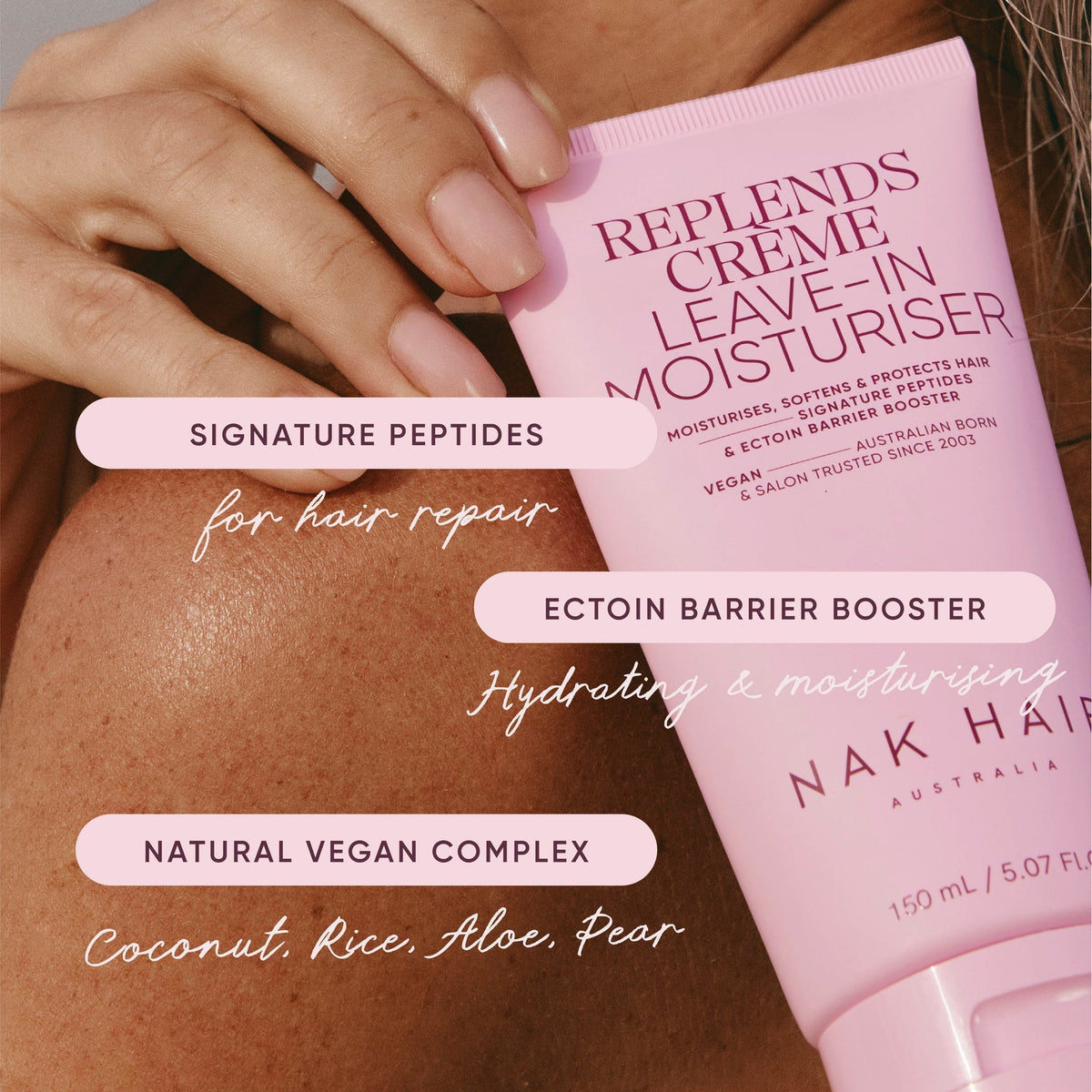 Pink hair care product with text about ingredients and benefits on a blurred background