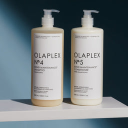 Olaplex No.4 Shampoo & No.5 Conditioner DUO bottles on a white ledge