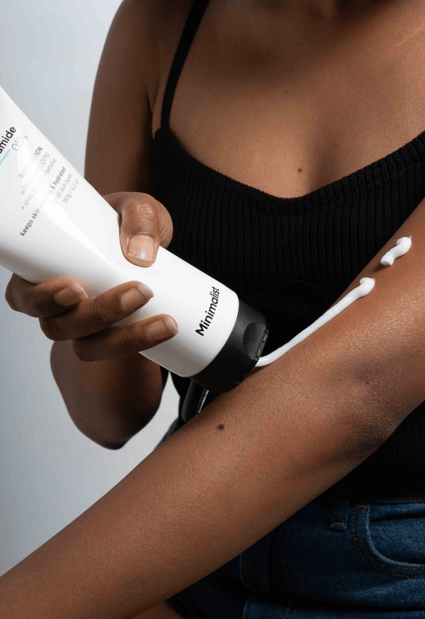 a person applying Minimalist Niacinamide 05% Body Lotion to her arms