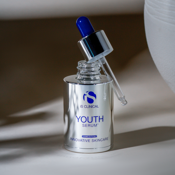 iS Clinical Youth Serum vial with its lid perched next to it