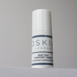 Skincare cream tube labeled 'Oskia London' on a gray background