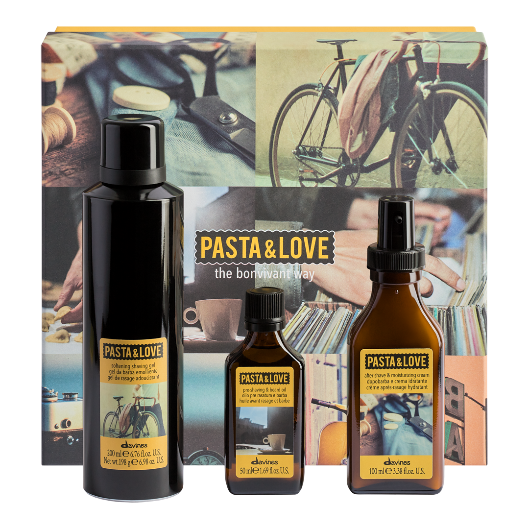 A boxed fragrance gift set from eluvos featuring three dark glass bottles with yellow labels in front of a decorative box. The set includes a tall matte black bottle, a smaller dark amber bottle, and a larger amber spray bottle.