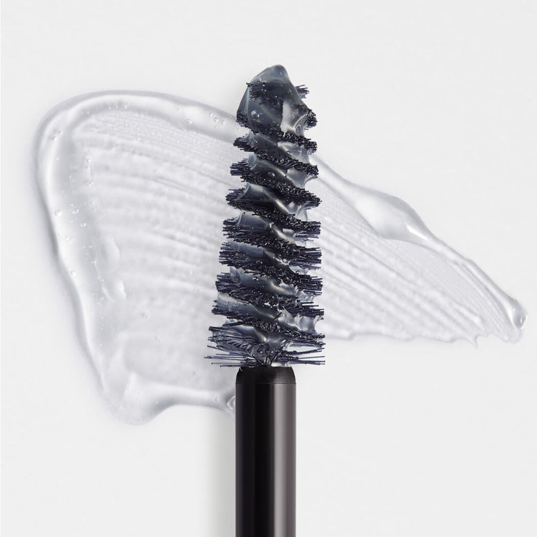 Eyebrow brush with black bristles and clear gel on a white background