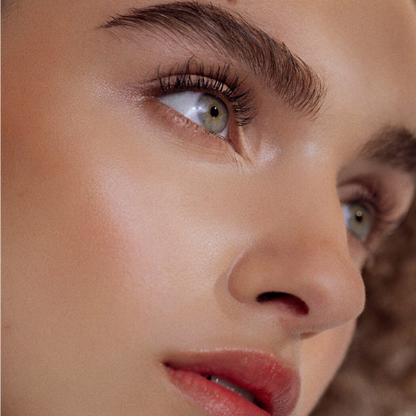 Close-up of a woman's face with a focus on her eye and nose.