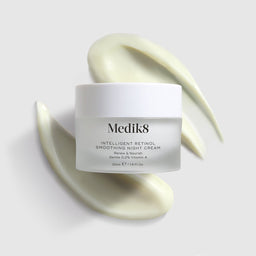 Medik8 Intelligent Retinol Smoothing Night Cream tub with texture behind it
