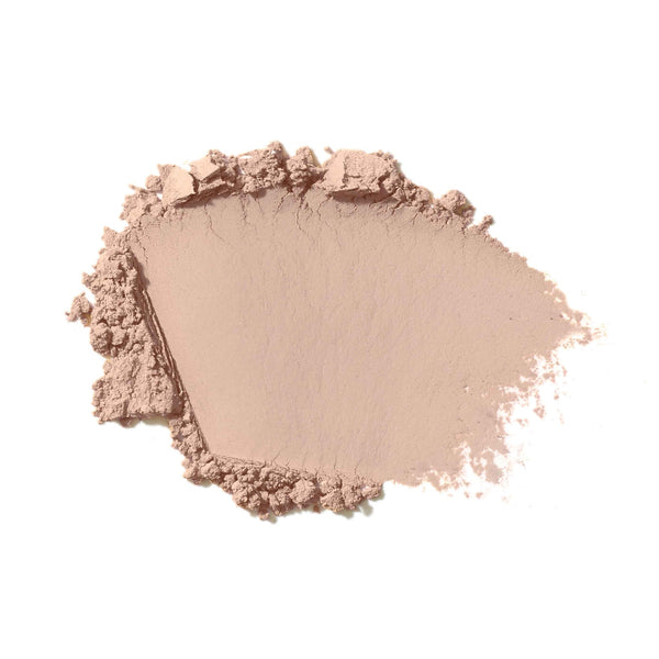 Nude-colored makeup powder on a white background