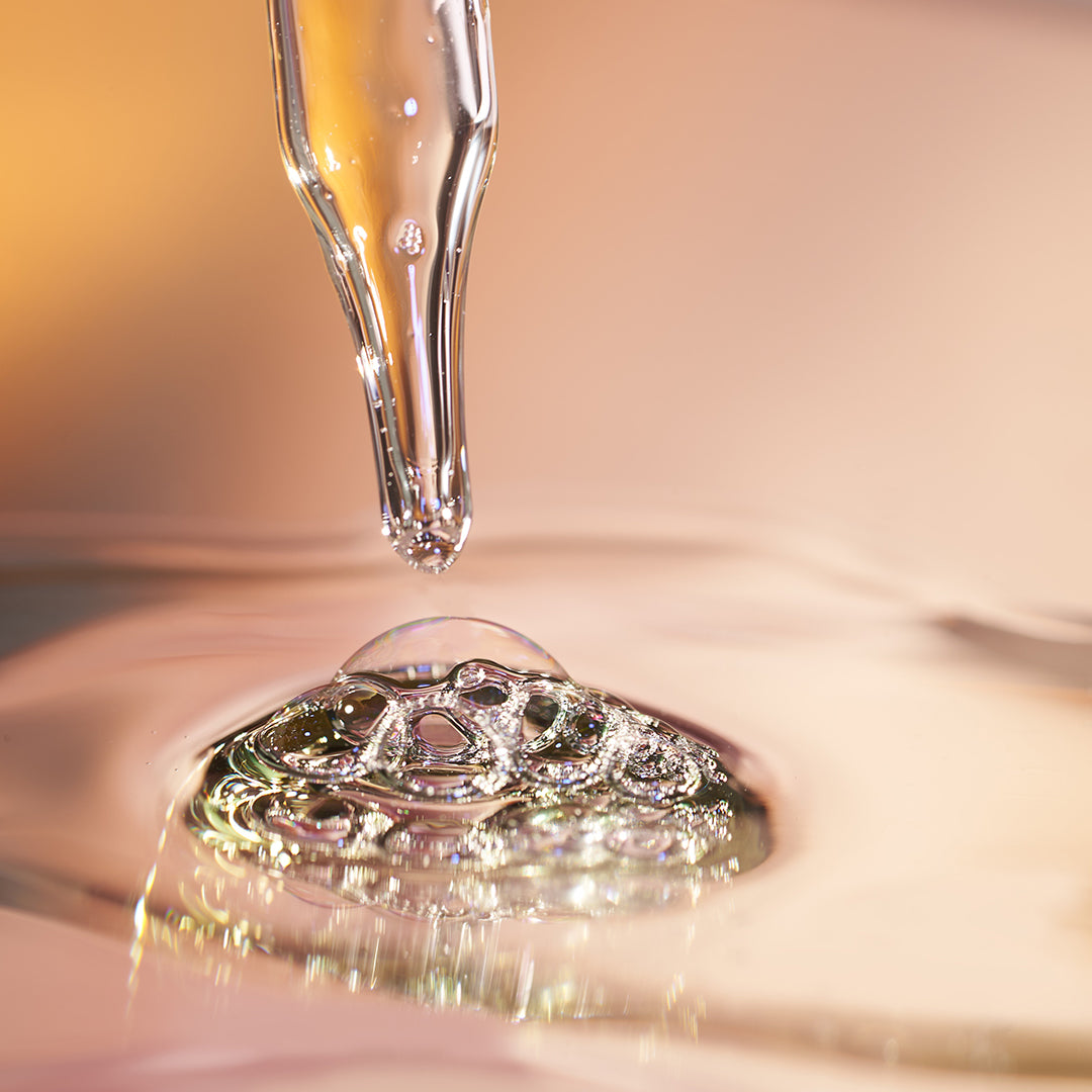 Dropper with liquid droplet on a reflective surface