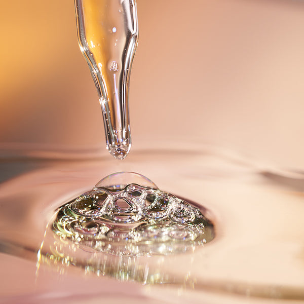 Dropper with liquid droplet on a reflective surface
