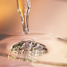 Dropper with liquid droplet on a reflective surface