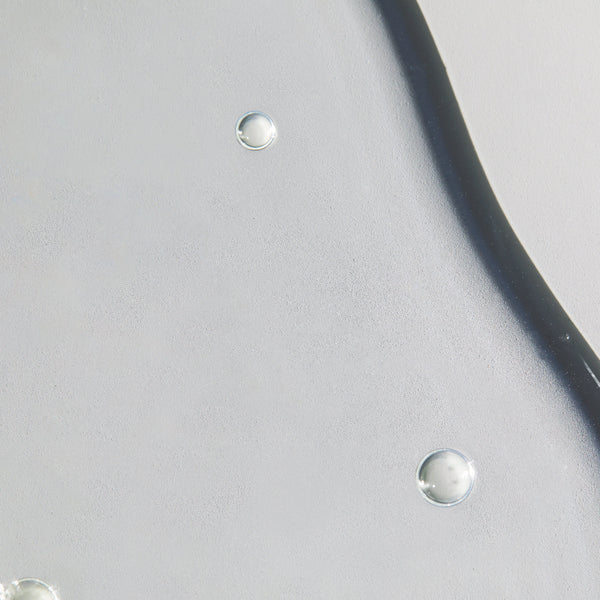 Close-up of a black cable with water droplets on a gray background