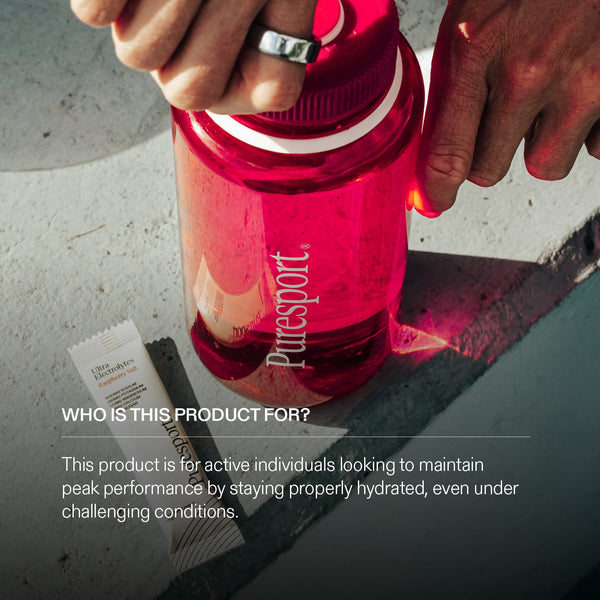 Red water bottle with a Puresport ogo on a concrete surface, with text about the electrolytes target audience 