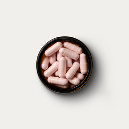 A open jar of supplements containing 90 capsules of magnesium. 