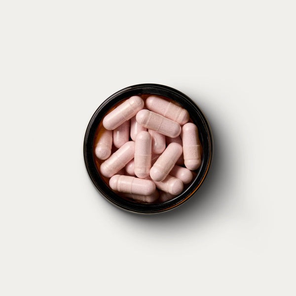 A open jar of supplements containing 90 capsules of magnesium. 