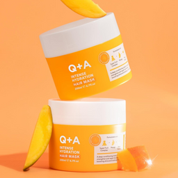 Two jars of Q+A Intense Hydration Hair Mask with bananas on an orange background