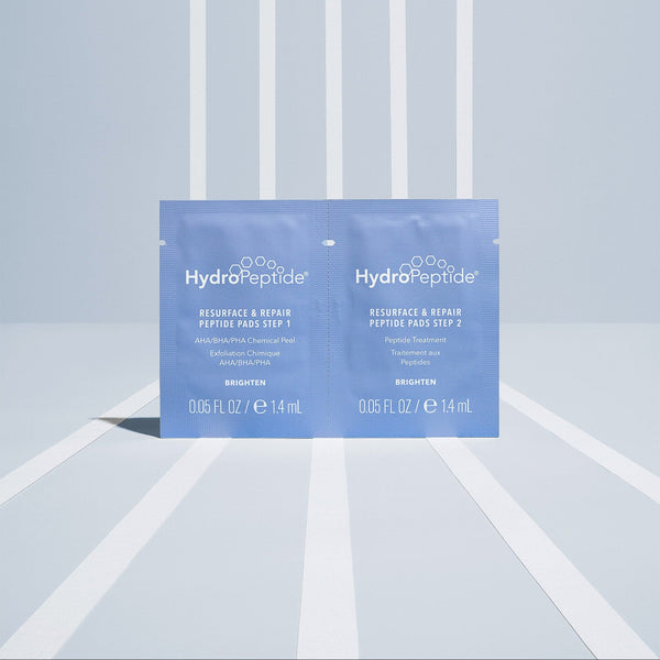 HydroPeptide skincare product packaging on a light blue and white striped background