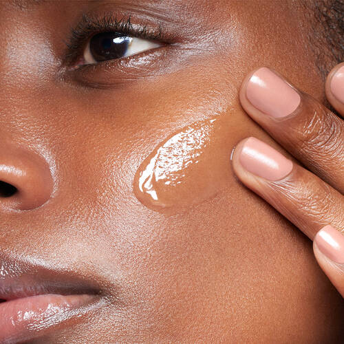 a woman applying SkinCeuticals Phloretin CF Gel to her cheek