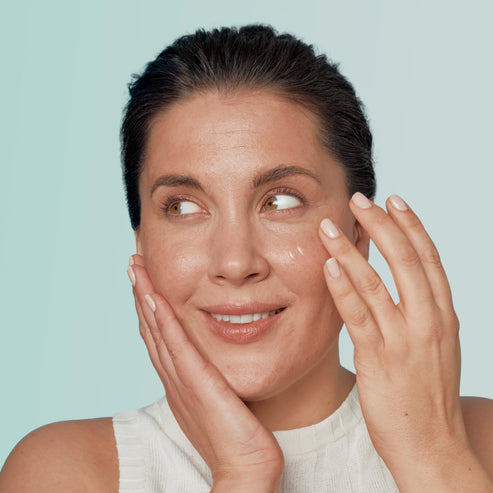 model applying the serum to her face