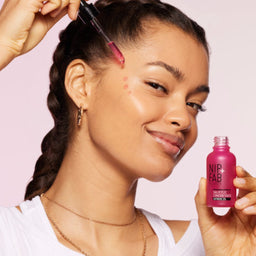 a model applying the serum to her face