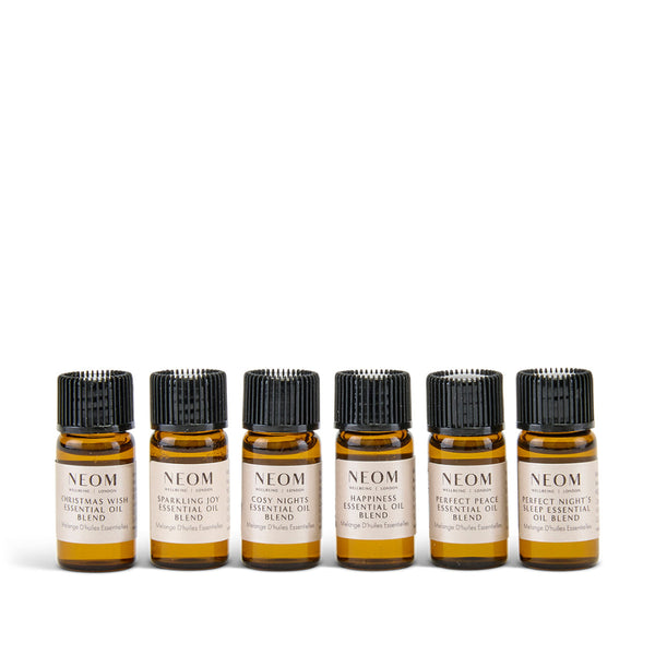 Set of six NEOM essential oil bottles on a white background