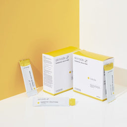 two packets of Skinade Targeted Solutions Cellulite next to a yellow wall