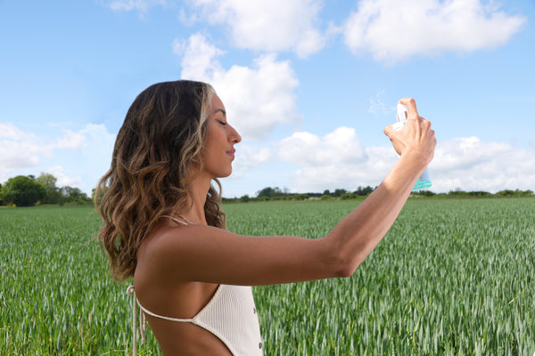 a women holding a bottle of Proto-col Hydrating Collagen Toning Mist while standing in a field