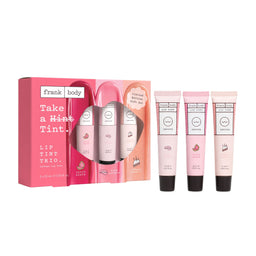 Frank Body Lip Tint Trio gift set with a pink box and three individual lip tint tubes in pink shades, displayed on a clean white background.