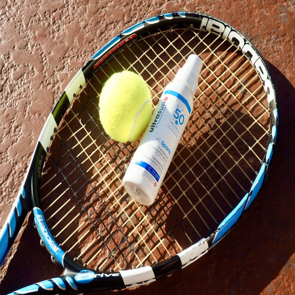 White Ultrasun Sports Spray SPF 50 150ml on tennis racket