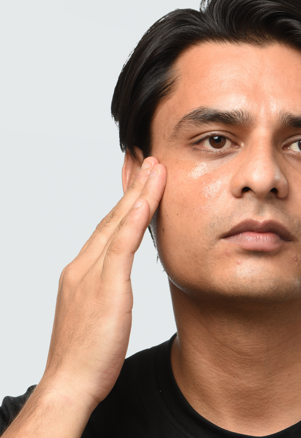a man applying Minimalist Vitamin C + E + Ferulic 16% to his face