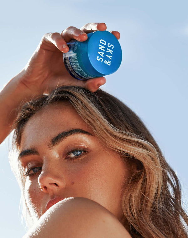 Model holding Sand & Sky Tasmanian Spring Water Hydration Boost Cream above her head