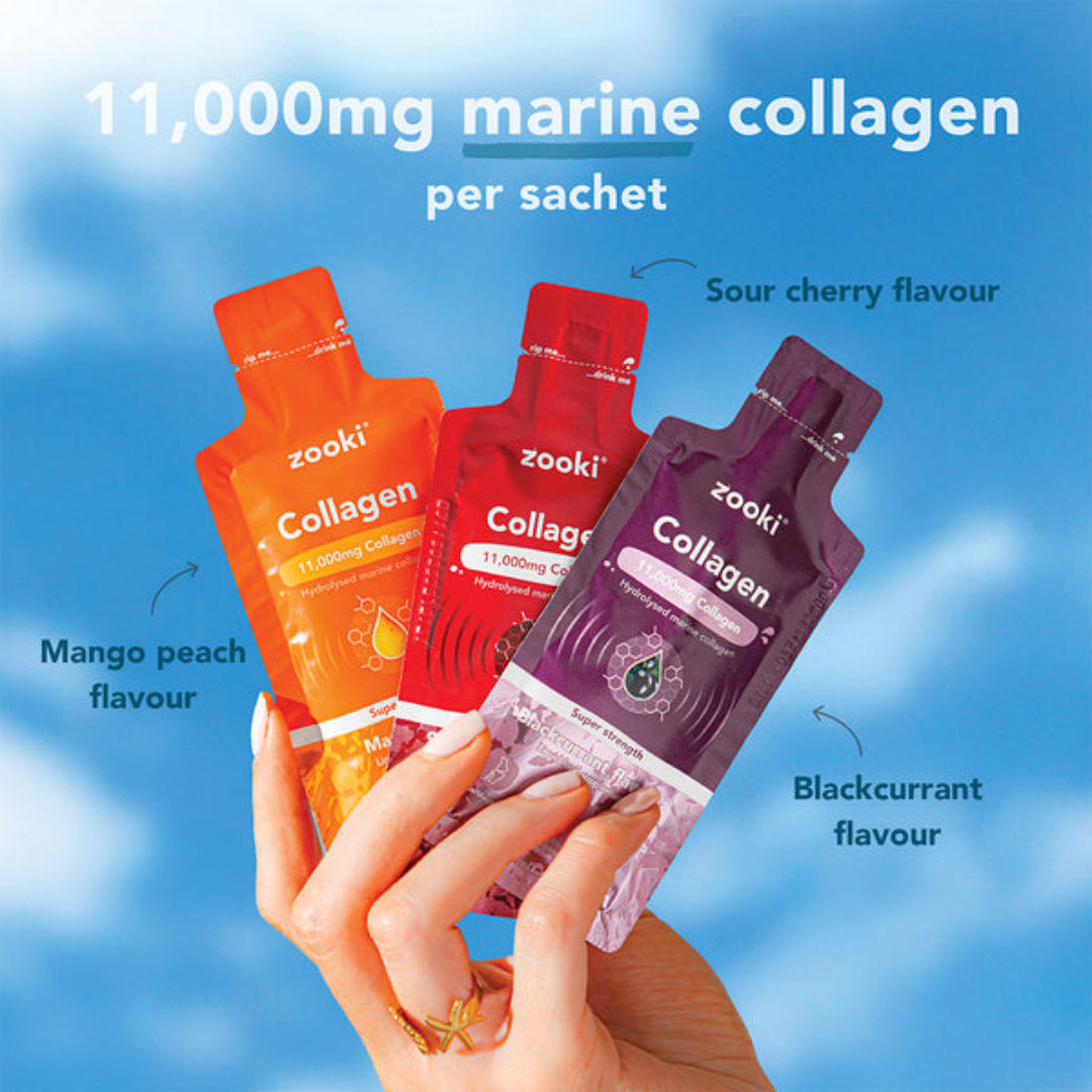 Three zooki collagen sachets in different flavors held by a hand against a blue sky background.