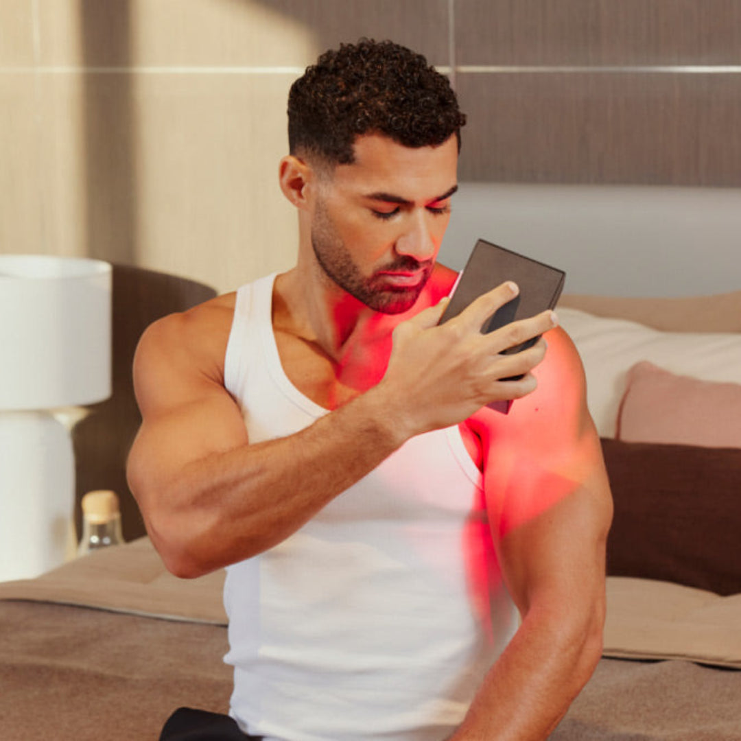 Man Using Mini Red Light Device on Shoulder