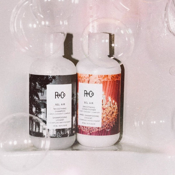 two bottles of R+Co Bel Air with bubbles surrounding it
